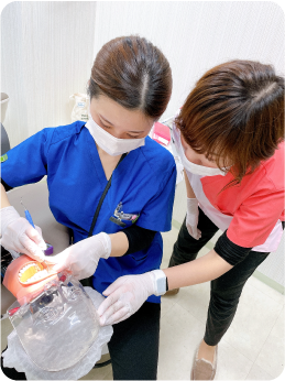歯科衛生士の技術をチェックする工藤彩加の写真